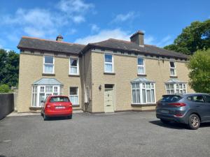 two cars parked in front of a brick house at Carraig Rua in Kilkenny