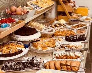 a buffet filled with different types of bread and pastries at Hotel Malpensa INN Aereoporto in Tornavento