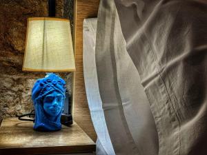een lamp en een blauwe buste naast een bed bij MaMa5 in Palermo +33 foto's