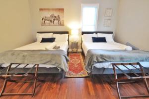 two beds sitting next to each other in a room at Housepitality - The Franklinton Inn - Location in Columbus