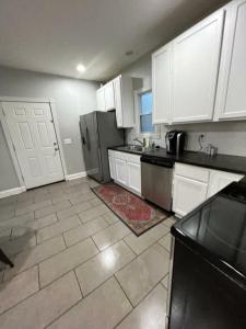 a kitchen with white cabinets and a refrigerator at Housepitality - The Franklinton Inn - Location in Columbus