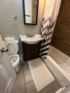 a bathroom with a toilet and a sink and a tub at Housepitality - The Franklinton Inn - Location in Columbus