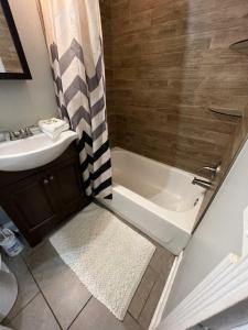 a bathroom with a shower and a sink and a tub at Housepitality - The Franklinton Inn - Location in Columbus