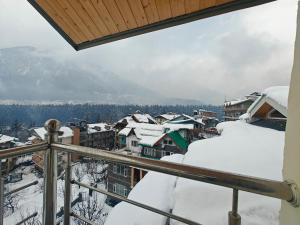 uitzicht op een stad bedekt met sneeuw bij Aleo Villa in Manāli
