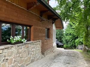 a stone wall next to a house with a window at Mała Bawaria in Zakopane