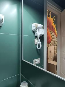 uma casa de banho com um espelho e um secador de cabelo em Schilizzi Hotel em Nápoles