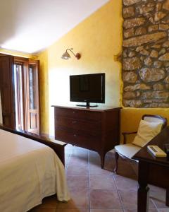 Castelnuovo ParanoにあるAl Piccolo Borgo Locanda Con Alloggioのベッドルーム(ベッド1台、ドレッサー内のテレビ付)