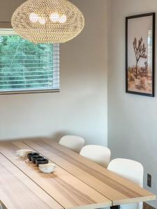 a dining room with a wooden table and a chandelier at Haven Rock- Secluded Oasis and Sanctuary Gardens in Joshua Tree +61 photos