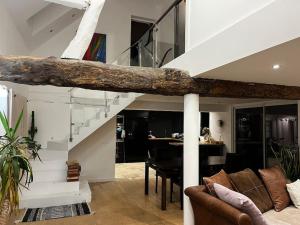 ein Wohnzimmer mit einem Sofa und einer Treppe in der Unterkunft Maison avec cheminée ancienne in Dives-sur-Mer