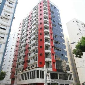 um edifício alto vermelho com varandas ao lado em Gonzaga Flat em Santos