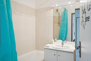 a bathroom with a sink and a bath tub at Appartement Chic avec terrace et parking in Sartrouville +12 photos