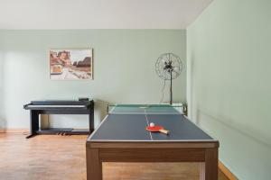 a ping pong table in a room with a piano at Appartement Chic avec terrace et parking in Sartrouville
