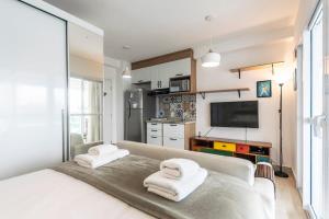 1 dormitorio con 1 cama grande y toallas. en BHomy Pinheiros Moderno e confortável CR134, en São Paulo