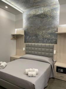 um quarto com uma cama com duas toalhas em Schilizzi Hotel em Nápoles