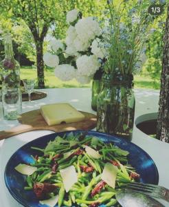 un plato azul de comida con una ensalada en una mesa en Dealettante glamping, en Bétaucourt