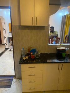 Ein Mann in der Küche, der in den Spiegel schaut. in der Unterkunft Famous gate Accomodation in Kericho