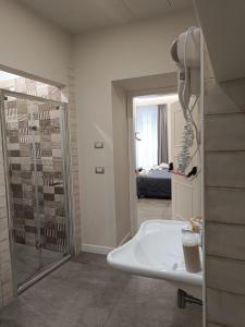 uma casa de banho com um chuveiro e um lavatório branco em Schilizzi Hotel em Nápoles