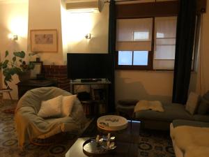 un soggiorno con divano e TV di CASA ROSA COSY PINK GUEST HOUSE a Torrão
