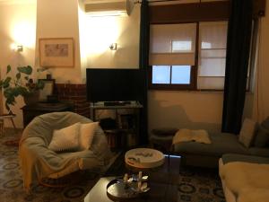 a living room with a couch and a tv at CASA ROSA COSY PINK GUEST HOUSE in Torrão