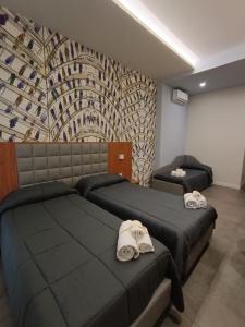 1 dormitorio con 2 camas y toallas. en Schilizzi Hotel en Nápoles