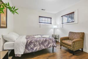 a bedroom with a bed and a chair at Housepitality - The Southern Orchards Cottage in Columbus