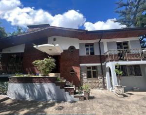 una casa de ladrillo con balcón en la parte superior en A Spacious 4BR 2 Bathroom Villa House @ Bole DT en Addis Abeba
