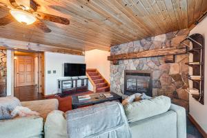 a living room with two couches and a stone fireplace at Rice Lake Cabin Retreat with Red Cedar Lake Access! in Rice Lake