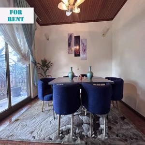 ein Esszimmer mit einem Tisch und blauen Stühlen in der Unterkunft A Spacious 4BR 2 Bathroom Villa House @ Bole DT in Addis Abeba