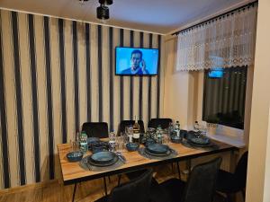een kamer met een tafel met stoelen en een televisie bij Apartamenty Premium Biznes Rumia in Rumia