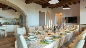 a dining room table with a long table with glasses at Casale con vista colline in Volterra