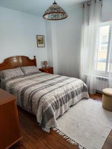 a bedroom with a bed and a window at Apartamento Pena Furada in Ribadeo