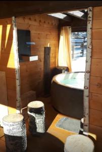 Cabaña de madera con bañera y 2 taburetes en Il Maiolandro, en Noasca