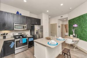 uma cozinha com armários pretos e um balcão branco em Lively Modern 1-Bedroom in Med Center em Houston