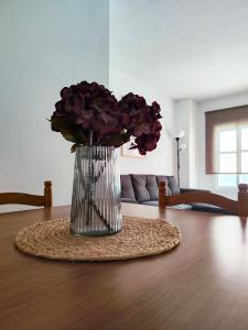 a vase of purple flowers sitting on a table at Apartamento Pena Furada in Ribadeo