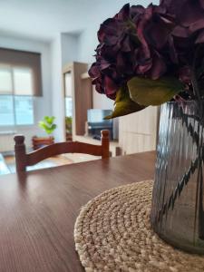 a vase filled with purple flowers sitting on a table at Apartamento Pena Furada in Ribadeo