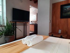 una sala de estar con una cama con toallas. en Hotel Valle Místico, en Tepoztlán