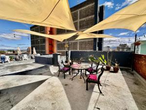 un patio con mesa y sillas bajo una sombrilla grande en Hostal Amaya en Guatemala