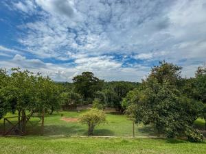 a view of a park with trees and a cloudy sky at Pousada Espaço do Sol in Araçariguama