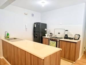 cocina con nevera negra y encimera en Apartamento Cielo Cajamarquino, en Cajamarca