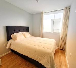 1 dormitorio con 1 cama grande y ventana grande en Apartamento Cielo Cajamarquino, en Cajamarca