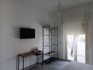 a bedroom with a tv and a shelf and a bed at CASA AL MARE LUXURY in Bari