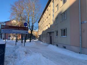 a snow covered street in front of a building at DIKOL Two-Room Apartment-SELF CHECK-in & FREE Parking Near City Center in Tallinn