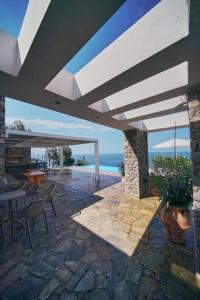 Un patio con mesa y sillas y el mar. en La Bella Villa, en Melínta