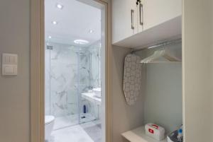 uma casa de banho com um chuveiro, um WC e um lavatório. em Koukaki Urban and Cozy Apartment em Atenas
