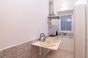 a white kitchen with a table and a sink at Deluxe Suite Welness in Rome +10 photos