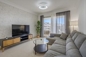 ein Wohnzimmer mit Couch und Flachbildfernseher in der Unterkunft Calm Palmar By W Tenerife in Palm-mar