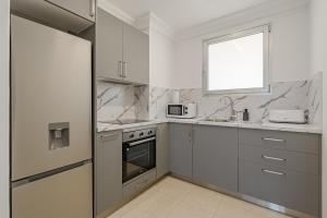 eine Küche mit weißen Geräten und einem Fenster in der Unterkunft Calm Palmar By W Tenerife in Palm-mar