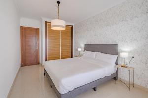 ein Schlafzimmer mit einem großen weißen Bett und zwei Lampen in der Unterkunft Calm Palmar By W Tenerife in Palm-mar + 18 Fotos
