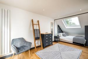 ein Schlafzimmer mit einem Bett, einem Stuhl und einem Spiegel in der Unterkunft Beautiful 3 bed Cottage Chorleywood. in Chorleywood