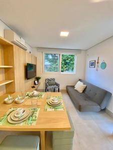 a living room with a table and a couch at Apartamento a 100 m da praia in Juquei
